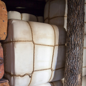 Large bales wrapped in canvas and stacked high