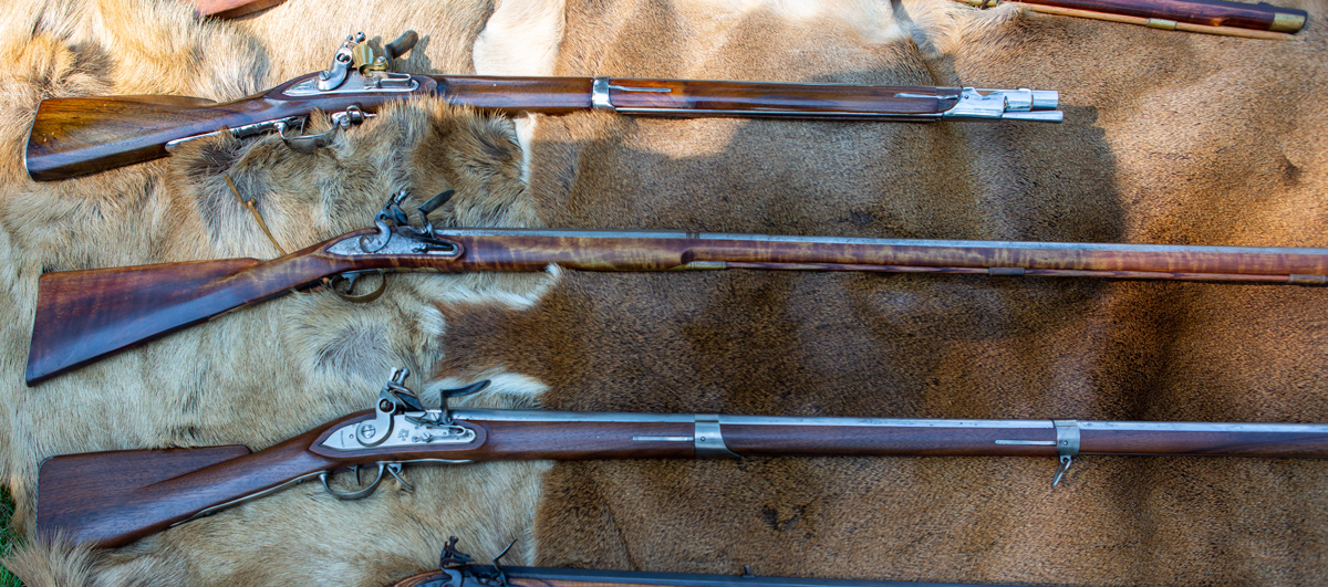 Several different muskets lying on an elk hide